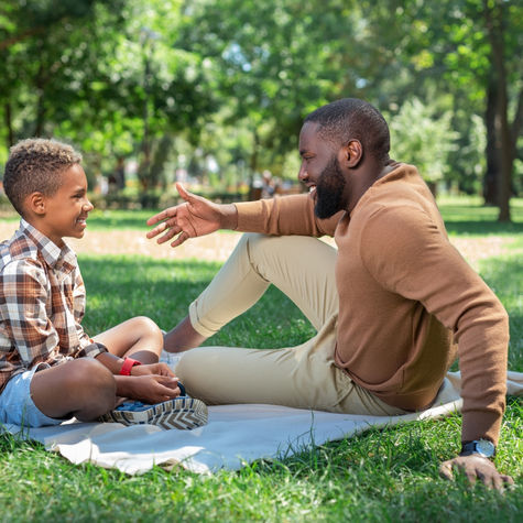 Dad sitting with child and giving full attention during conversation, showing present parenting and connection.
