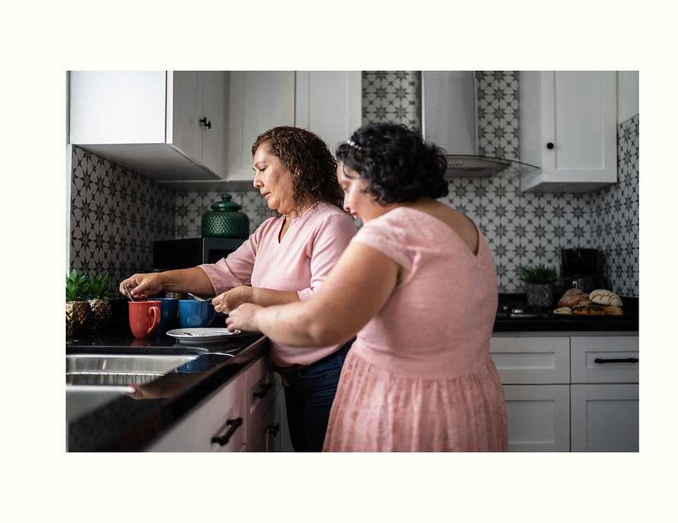 Young woman learning to wash dishes in the kitchen with guidance from her Independent Living Skills
