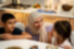 A teacher wearing a hijab addressing the concerns of a young girl and boy in a homeschooling environment.