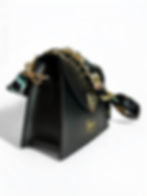 Side profile of black diamond-shaped leather handbag with sleek silhouette and strap