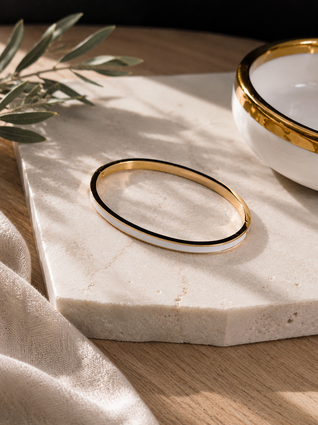 Gold hinged bangle with white enamel strip