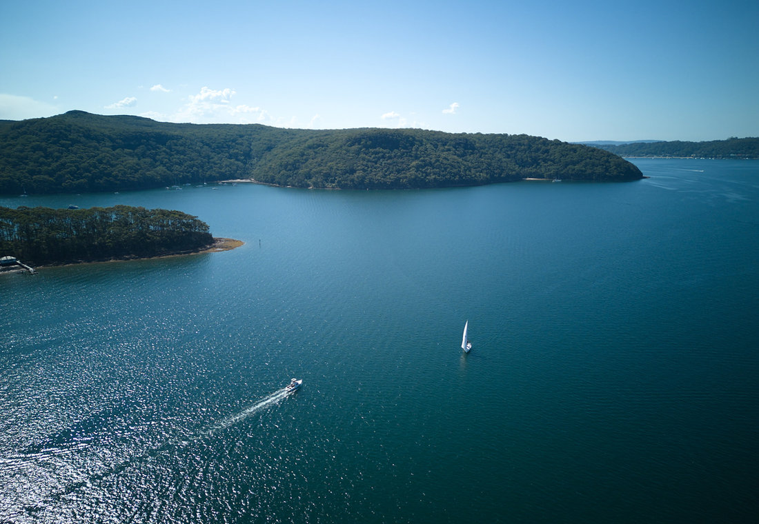 Wide calm water of Pittwater with a lone yacht