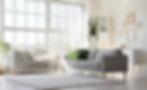 Interior of light living room with cozy grey sofas near big window.jpg