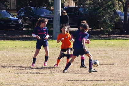 Young girls contesting ball in soccer match