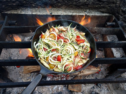 Gemüsepfanne in der Pfanne auf dem Lagerfeuer. Die Waldoase.