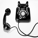 black rotary dial phone on white surface