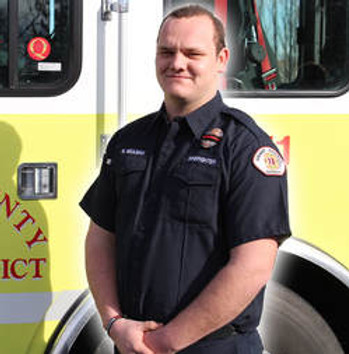 Battalion Chief Matthew Meulman in front of engine 1311.