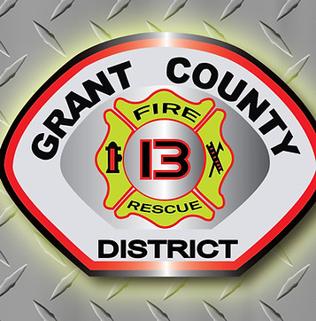 District 13 patch in front of diamond plate with a yellow glow around it.