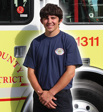 Firefighter Ethan Black in front of Engine 1311
