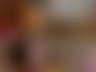 A woman with brown hair in a ponytail in lying on a couch and her ginger cat is lying along the top of the couch.