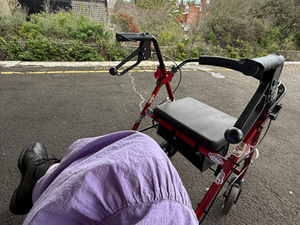 a photo taken on a train station platform of a red and black walker