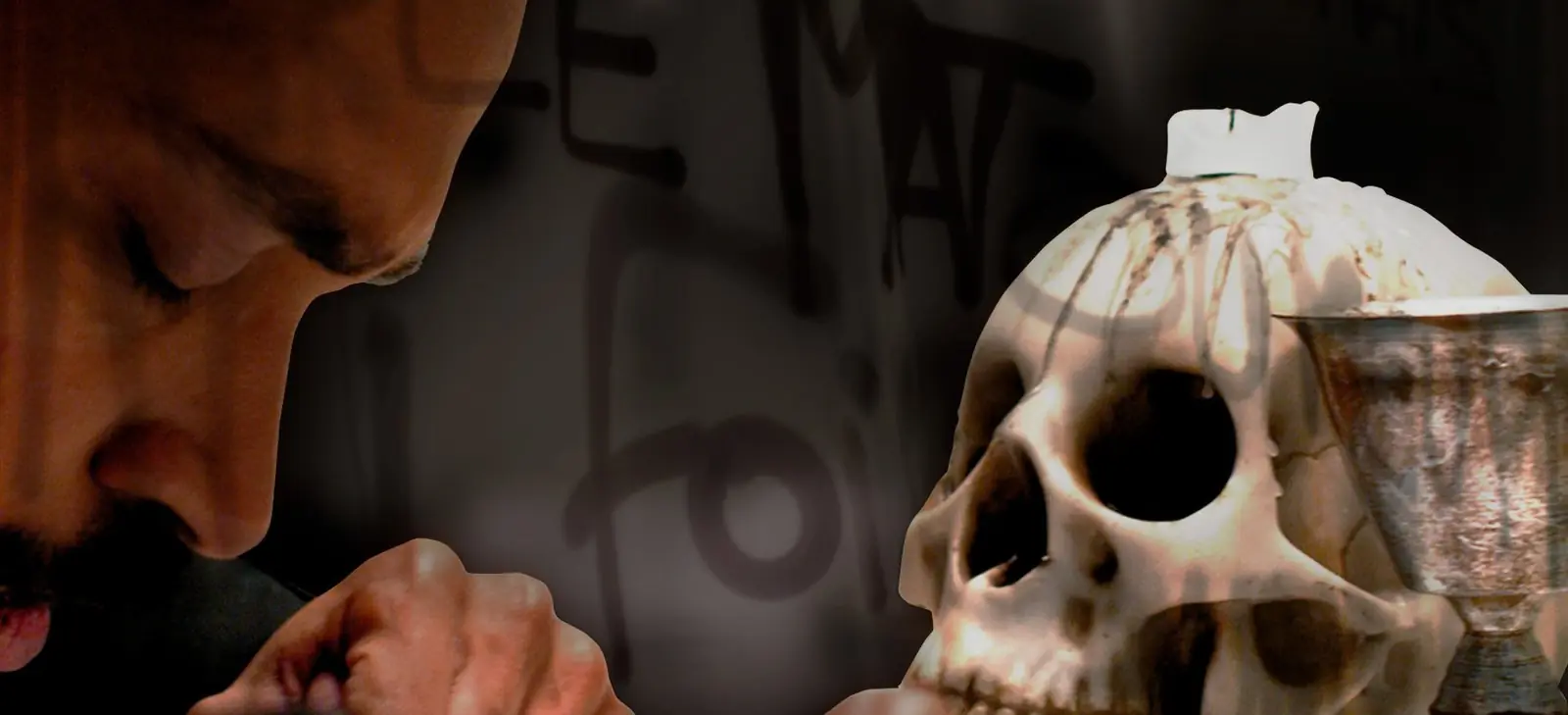 Hamlet debruçado sobre o roteiro, ao lado de uma caveira e um cálice