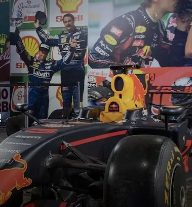 Exposição 50 anos de GP no Brasil: carro de Fórmula 1 em primeiro plano e painéis com pilotos ao fundo
