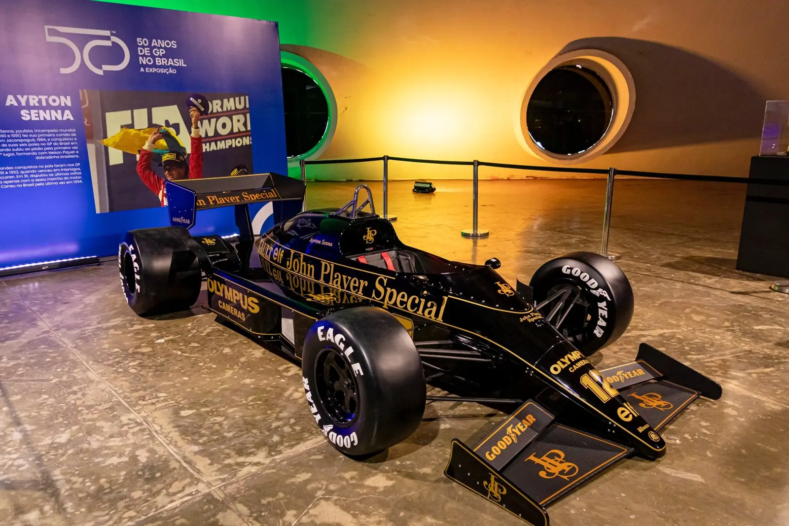 Lotus preta e dourada de Ayrton Senna exposta na Oca, diante do painel do piloto