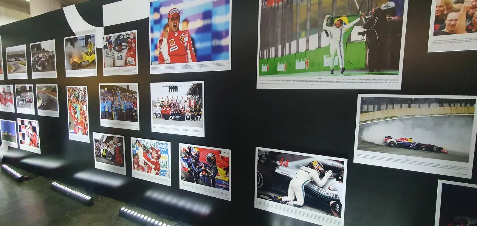 Parede preta com dezenas de fotos históricas do GP do Brasil