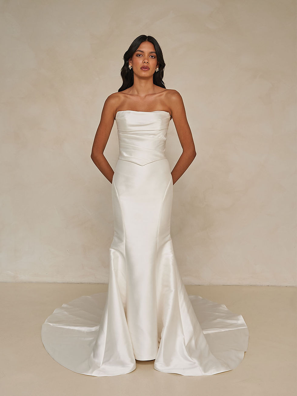 Thumbnail: Model wearing Winston Bodice by Madi Lane paired with fitted satin mermaid skirt, modern minimalist bridal silhouette