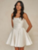 Model wearing the Williams Skirt by Madi Lane satin mini bridal dress with strapless neckline and fitted waist.
