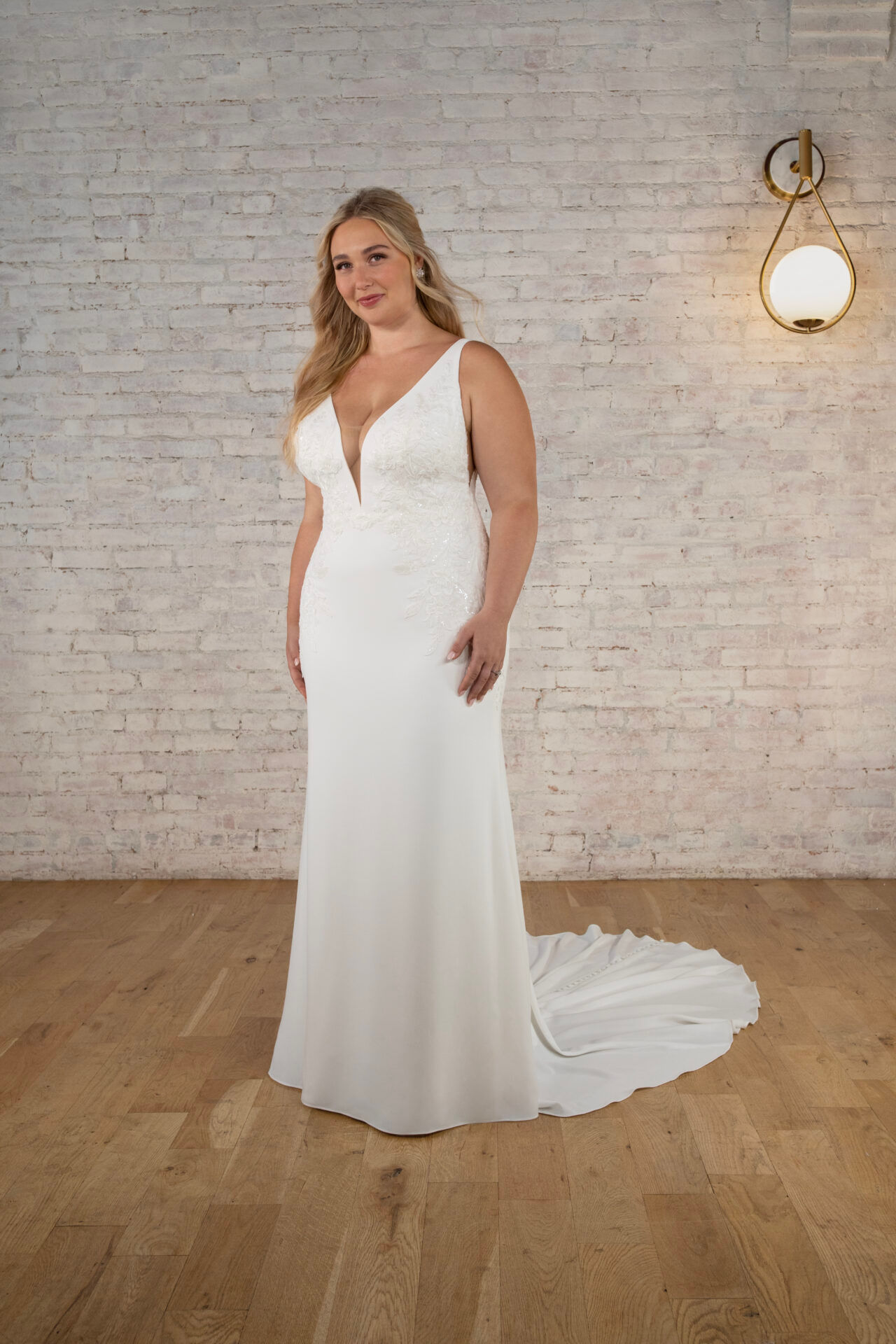 Stella York 7774 bridal gown showcasing the plunging V-neckline, subtle lace bodice detailing and sleek crepe skirt worn