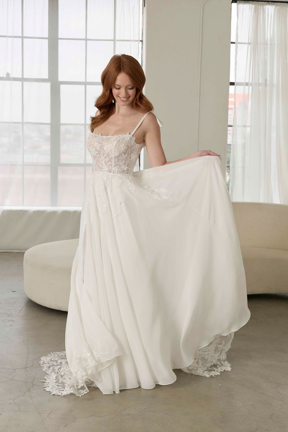 Flowy chiffon bridal gown with floral lace bodice and soft A-line skirt, captured in natural light.