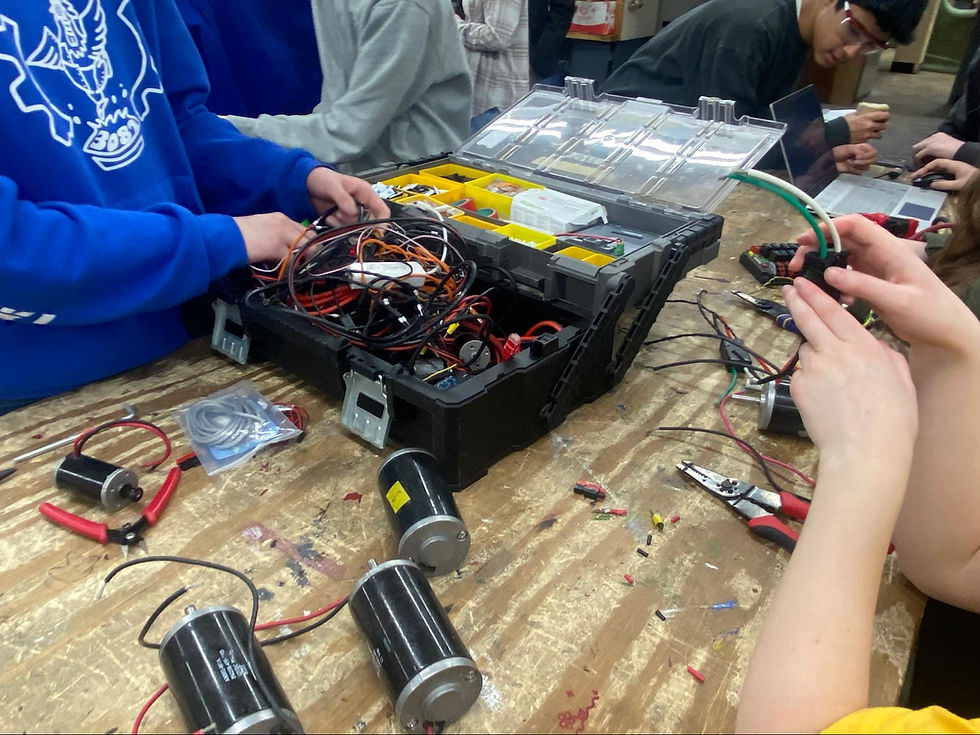 Image of the wires in a motor that are being fixed by many programming members.
