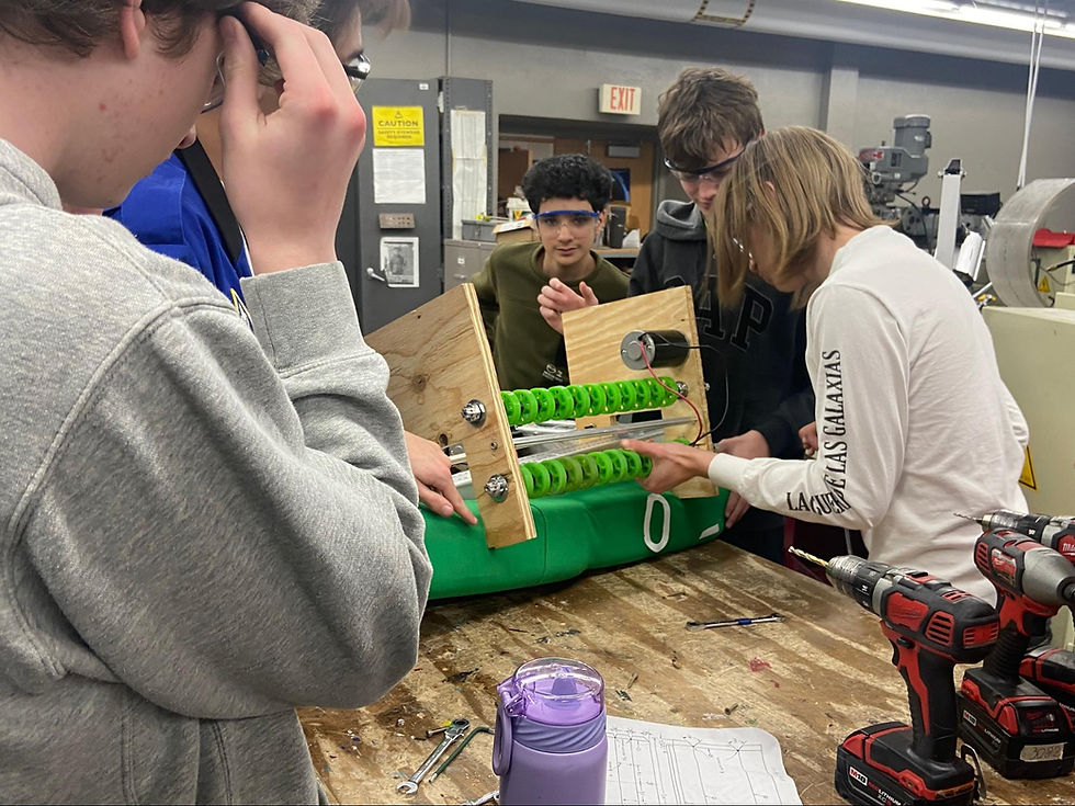 Build members working a wooden prototype intake for the robot.