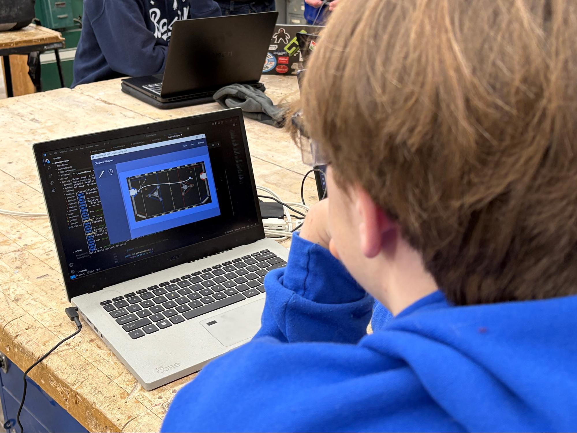 Oliver J., wearing a blue team hoodie and safety glasses, is working on creating Bezier Splines on a laptop at a wooden table. The laptop screen shows a software interface titled 'Obstacle Planner'.