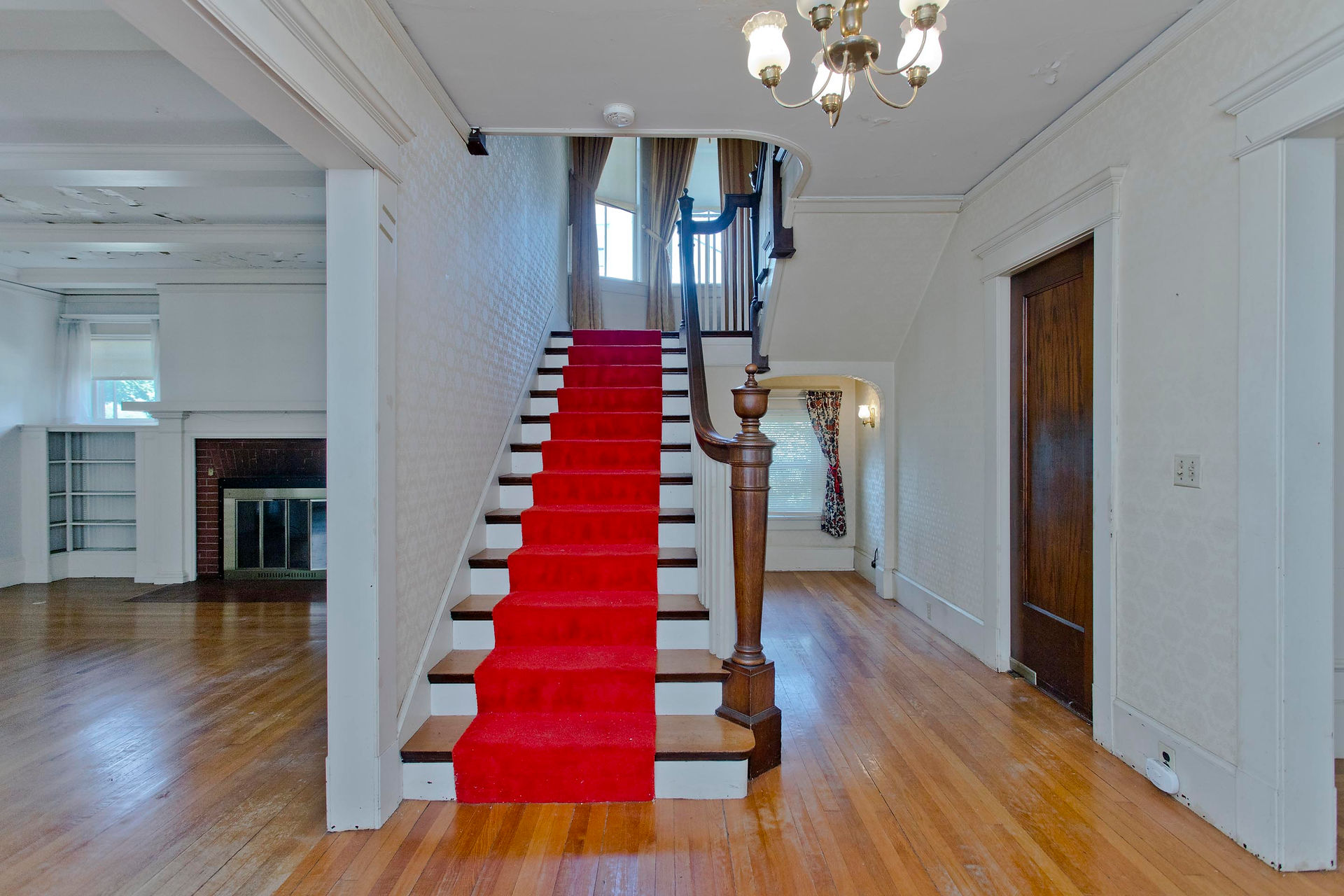 Big front stairway. On one side is a hall, the other has a living room and fireplace.  