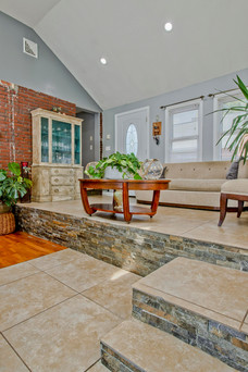 A split level three season porch. It has vaulted ceilings and ample skylights. Double French doors lead to the pool.