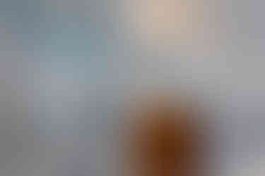 A grey full bath with a curved wood vanity and tiled wall.