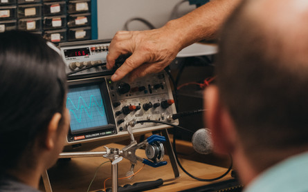 Older professor shows students sound waves so they can meassure how quickly the sound is traveling.