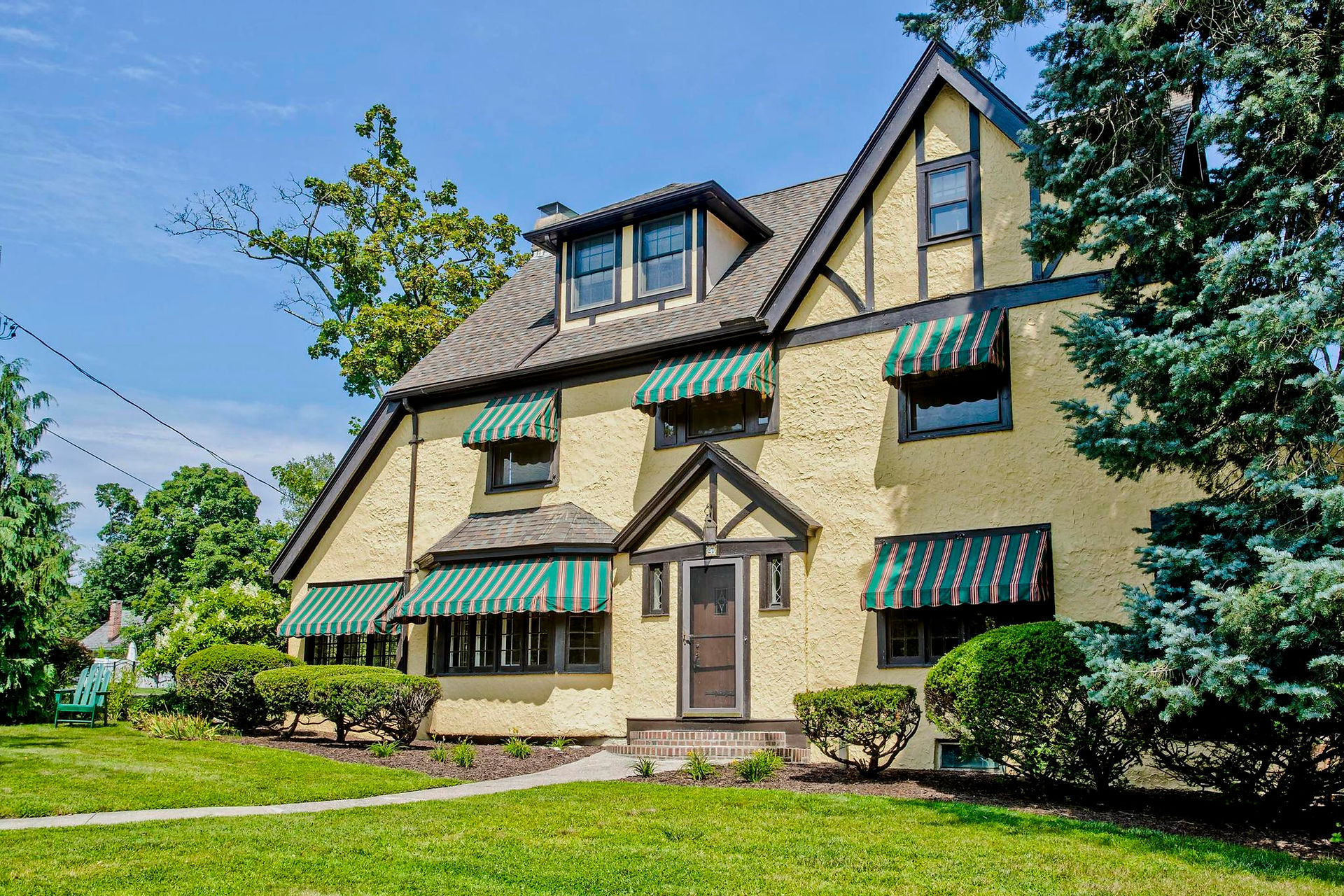 An enormous tan English tutor in Holyoke's highlands. It has green awnings, wood trim, and a nice winding path and well maintained shrubs. Easily one of the most stunning buildings in Western MA.  