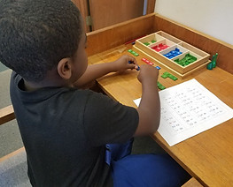 a little boy playing with colored pattern toys working on learning shapes and numbers. 