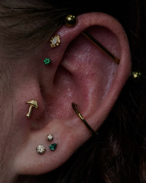 Ear curation with gold and emerald jewelry done by Shaun Gray in Cary North Carolina