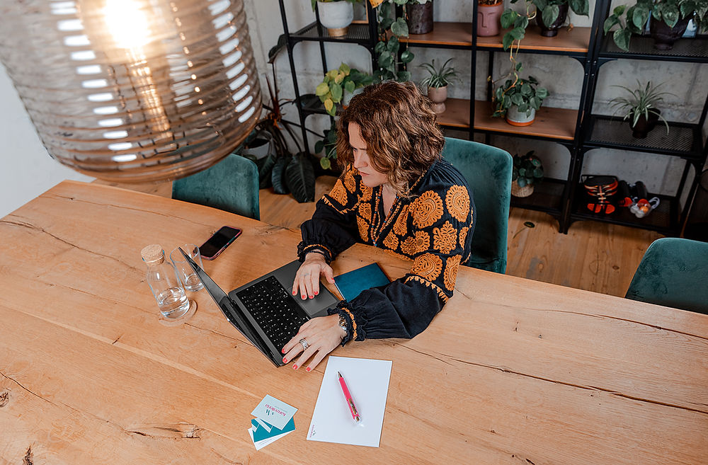 kanzelleria_Anja_Sophie_Betzler_von oben fotografiert am Holztisch sitzend mit Laptop arbeitend