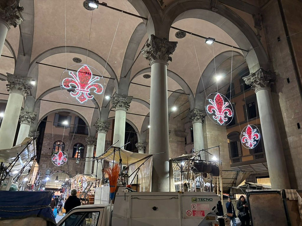 A Central Florence Market and the lit up Fleur-de-lys symbol of Florence, which interestingly has its origins in the 1792 French Revolution.