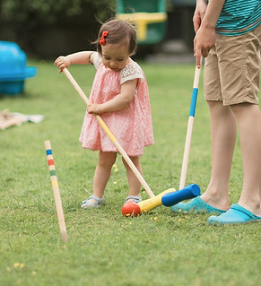 Family game in a summer garden Kids playing croquet game on a grass at back garden.jpg