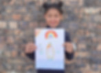 Girl proudly holding up her artwork