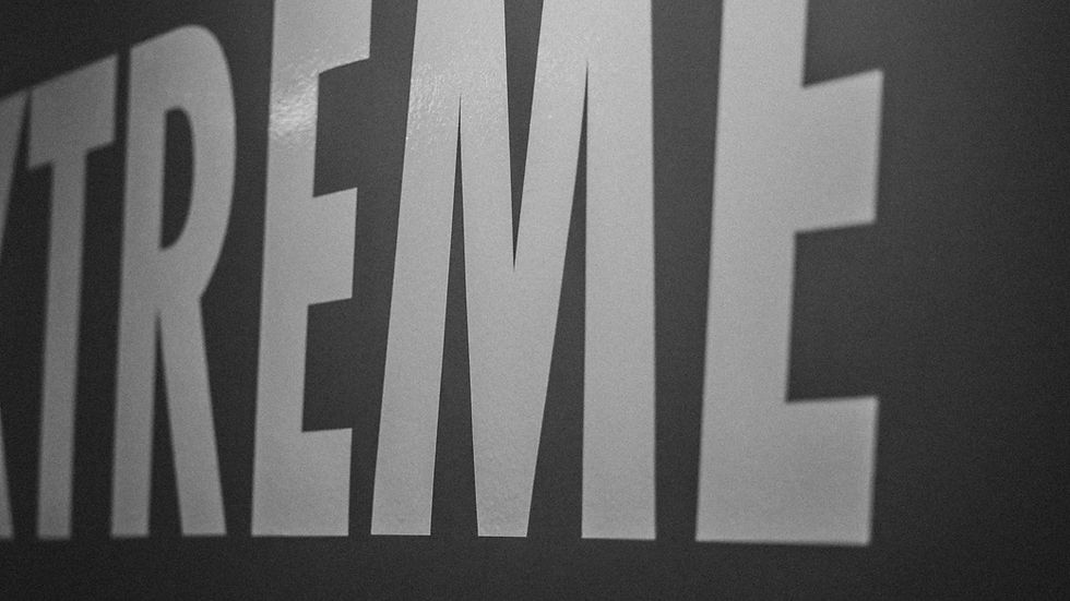 Close-up of large, bold letters spelling "XTREME" on a dark background. The image is in black and white with a strong, intense mood.