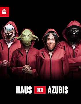 Ein Kampagnendesign mit schwarzem Hintergrund. Darauf vier Personen in roten Overalls mit Kapuze, jede trägt eine Maske:
Vorne rechts eine Person mit einer Maske, die das Gesicht einer älteren Frau mit dunklem Haar zeigt. Dahinter links eine Person mit Yoda-Maske, die sich mit der linken Hand die rechte Hand hält. Links daneben eine Person mit Hai-Maske, deren rechte Hand mit einem Ring sichtbar ist. Hinten rechts eine Person mit schwarzer Gorilla-Maske und verschränkten Armen.
Oben links im Bild das rot-weiße Sparkassen-Logo. Unten mittig auf Beinhöhe der Schriftzug: „Haus der Azubis“ in rot-weiß.
Das Motiv ist Teil einer auffälligen Recruitingkampagne für die Sparkasse und zeigt, wie wir bei der neo.says.miau. GmbH kreative Wege zur Ansprache junger Talente gestalten.