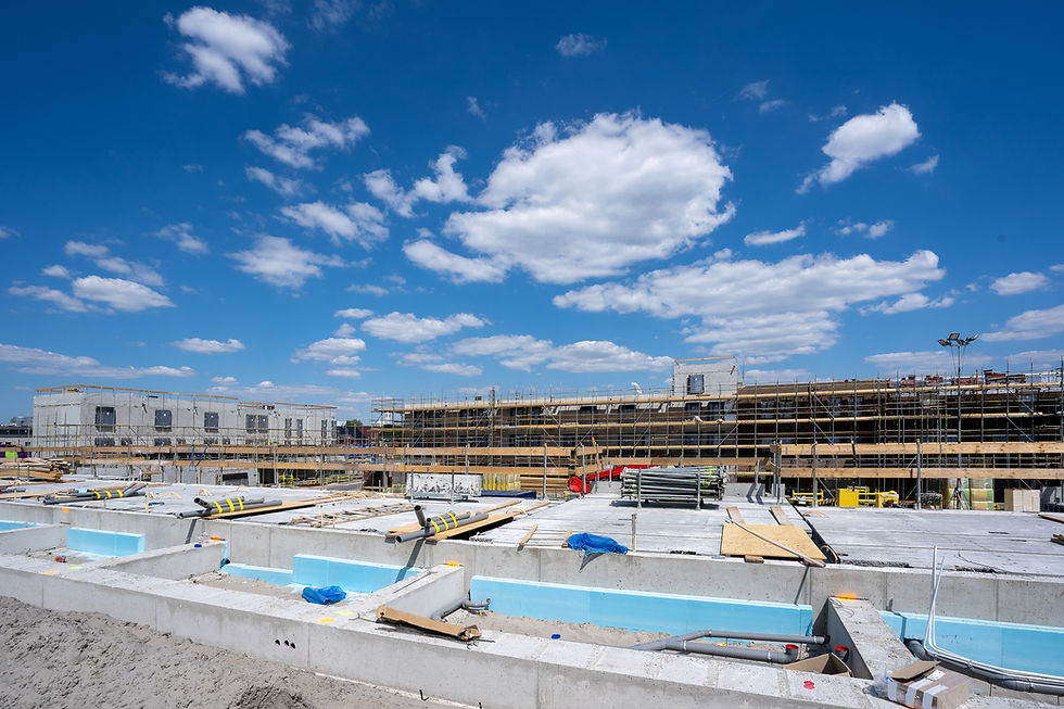 disparo-horizontal-de-un-sitio-de-construccion-con-andamios-bajo-el-cielo-azul-claro.jpg