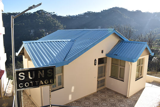 Front view of charming SUNS Cottage nestled amidst lush greenery