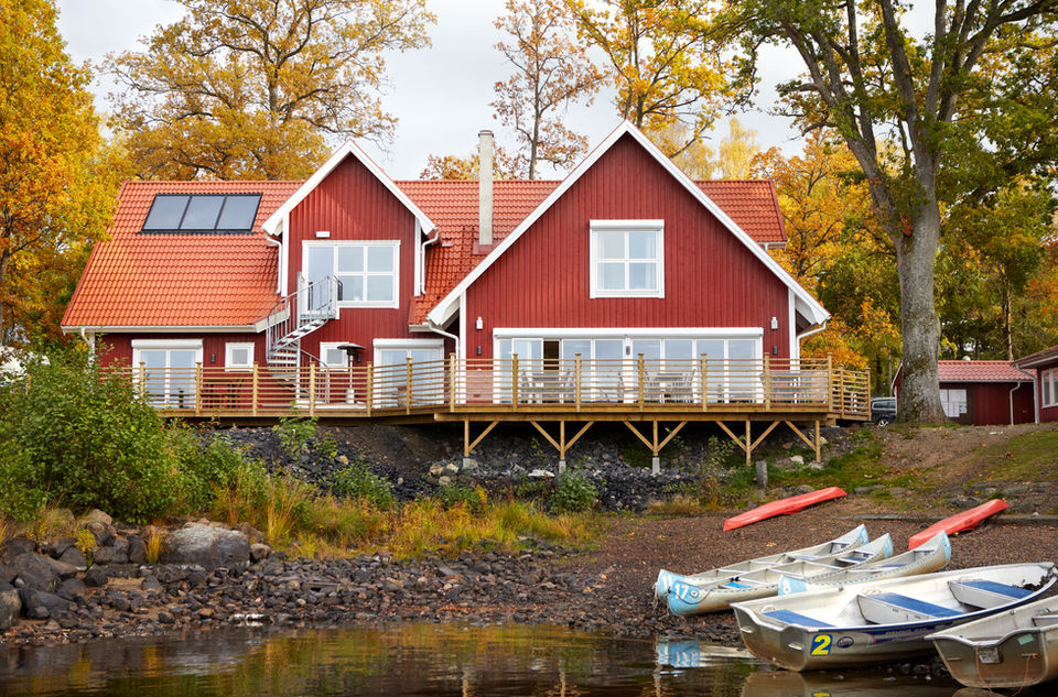 Rött hus med stor altan vid sjö och båtplats – nybyggnation och altanbygge byggfirma Småland