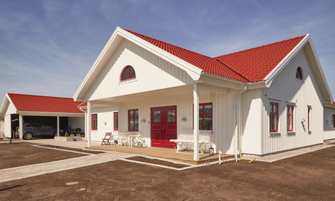 Vitt enplanshus med rött tegeltak och veranda – nybyggnation villa byggfirma Småland