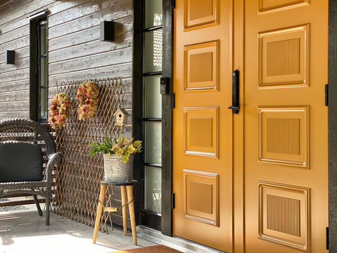 Öppen gul trädörr med höstdekoration – entré dörrbyte och renovering