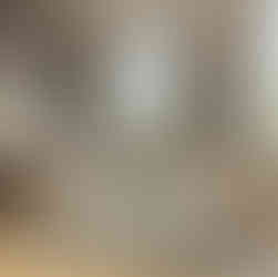 A chic living room featuring a bespoke carpet with a unique, intricate geometric pattern, enhancing the room's overall look with stylish furniture and natural light.