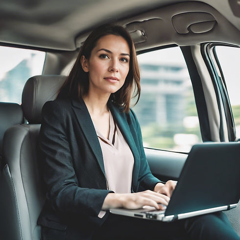 image of a women sitting in back seat of a car and working in laptop while travelling to o