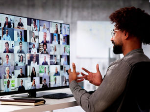 A man engages in a video conference with nonprofit professionals, representing remote collaboration and strategic planning support.