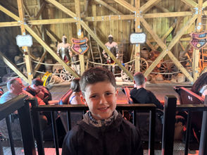Child waiting at an amusement-park ride—metaphor for nonprofit leadership staying mission-focused amid unfair outcomes and shifting rules.