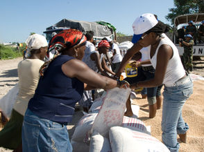Volunteers distributing emergency food—humanitarian relief sustained by recurring donors and monthly giving.