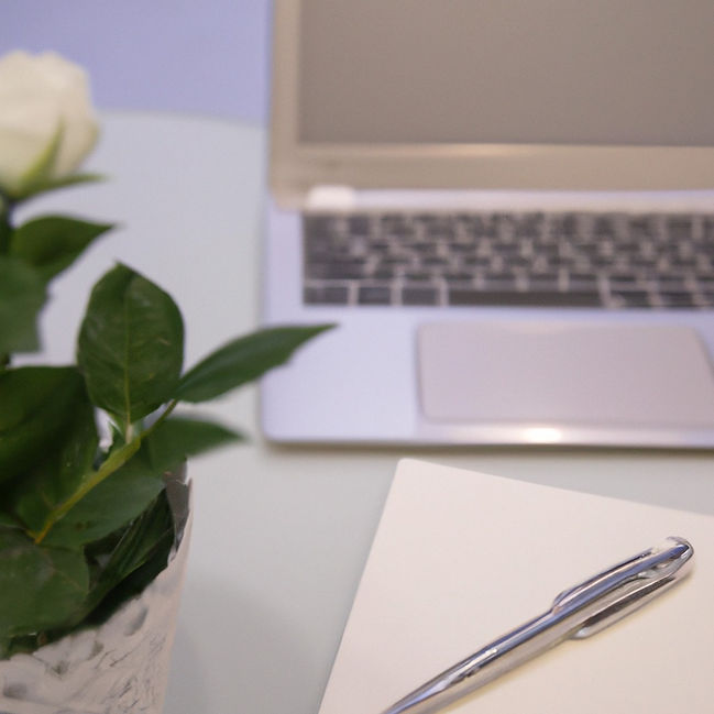 office desk, pen and paper, laptop, vase of flowers.jpg